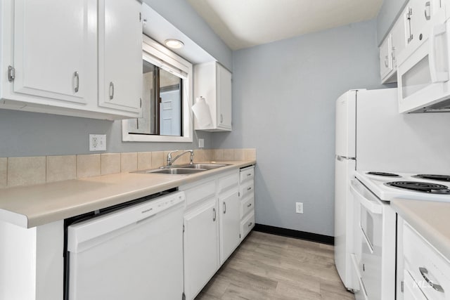 kitchen with white cabinets, a sink, white appliances, light countertops, and light wood-type flooring