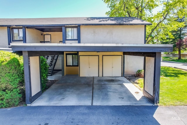 exterior space featuring stucco siding and stairway