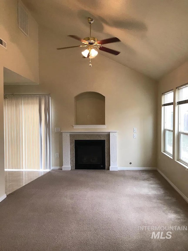 unfurnished living room with carpet floors, lofted ceiling, ceiling fan, and a tile fireplace