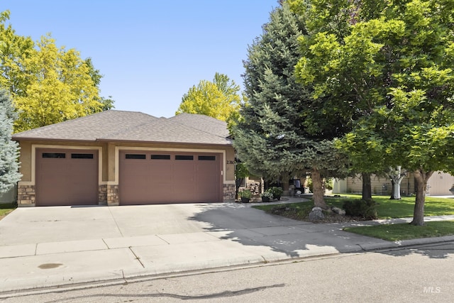 2310 W Herron Loop, Nampa, ID 83686 - view of front facade with an attached garage, concrete driveway, stone siding, roof with shingles, and stucco siding