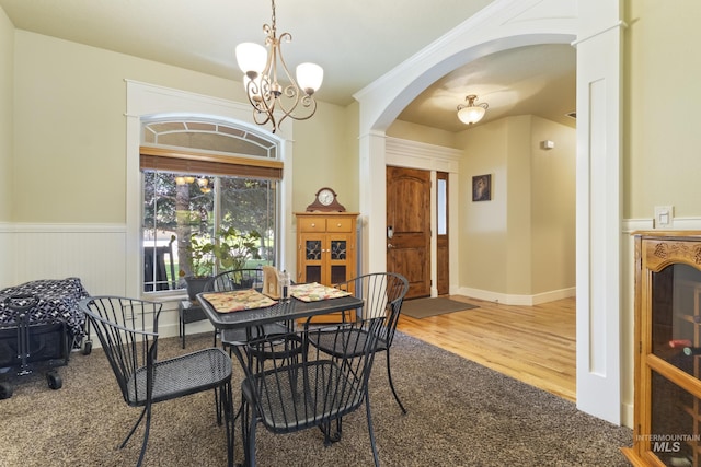 2310 W Herron Loop, Nampa, ID 83686 - dining room with arched walkways, a chandelier, wainscoting, wood finished floors, and carpet
