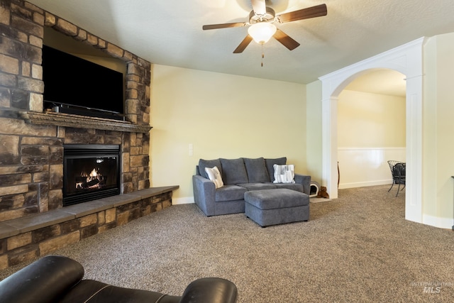 2310 W Herron Loop, Nampa, ID 83686 - living room with a stone fireplace, carpet flooring, a ceiling fan, and arched walkways