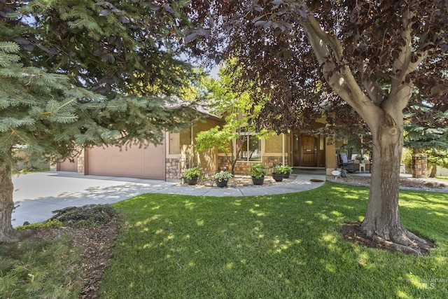 2310 W Herron Loop, Nampa, ID 83686 - obstructed view of property with concrete driveway, a front yard, stone siding, stucco siding, and an attached garage