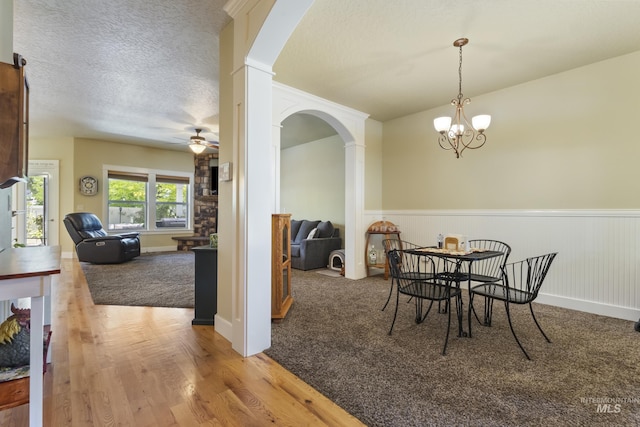 2310 W Herron Loop, Nampa, ID 83686 - carpeted dining area featuring arched walkways, wainscoting, a ceiling fan, a chandelier, and wood finished floors