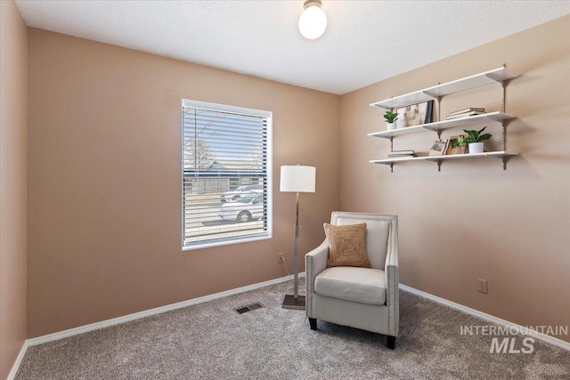 living area with a textured ceiling and carpet