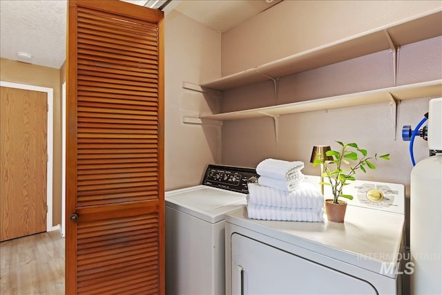 laundry room featuring washer and dryer and light wood-type flooring