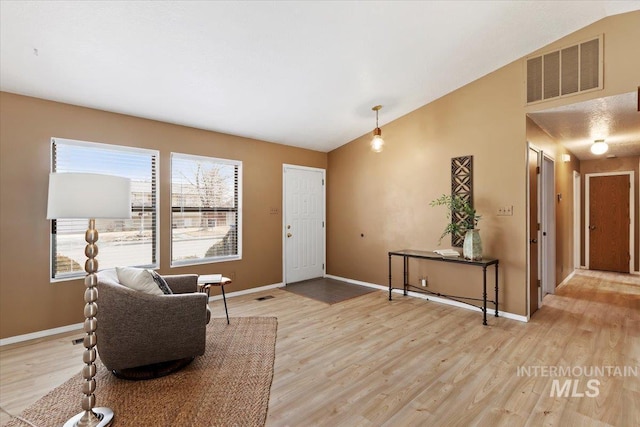 sitting room featuring vaulted ceiling and wood-type flooring