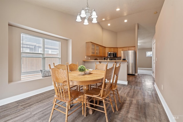 dining area with a high ceiling, dark wood-style flooring, recessed lighting, and baseboards