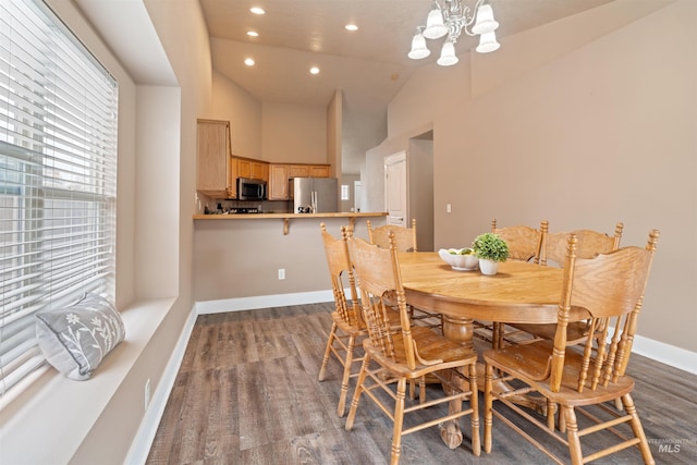 dining area featuring high vaulted ceiling, recessed lighting, wood finished floors, and baseboards