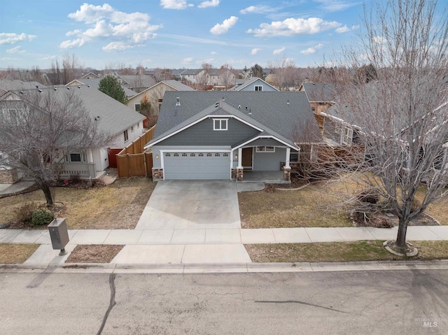 view of front of house with concrete driveway, a residential view, an attached garage, covered porch, and fence