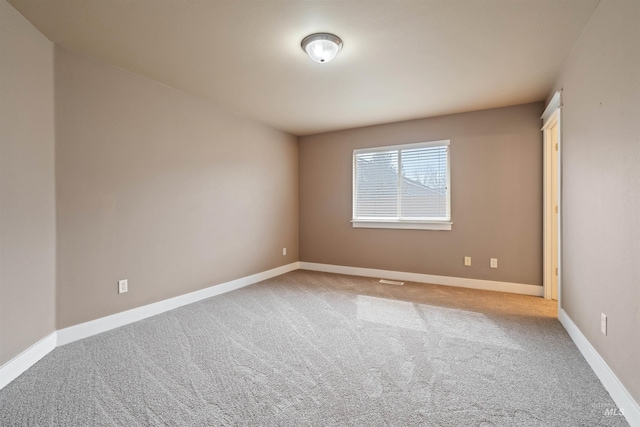 carpeted empty room with baseboards