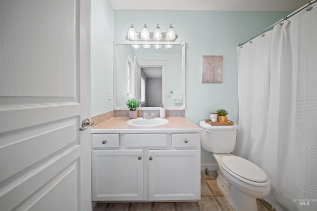 full bathroom featuring curtained shower, vanity, and toilet