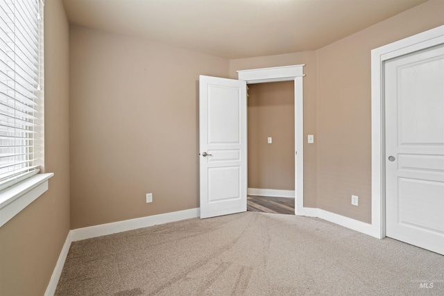 unfurnished bedroom with carpet and baseboards