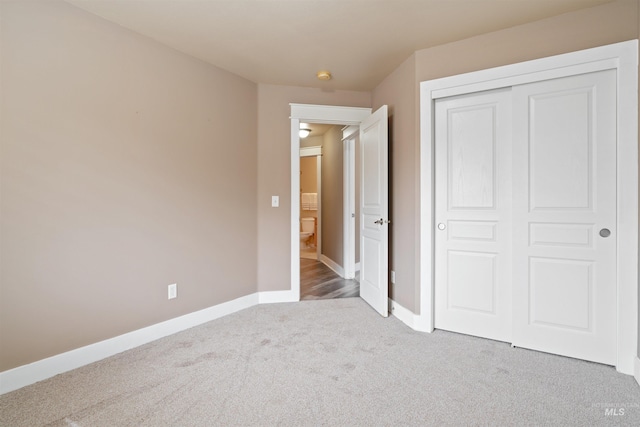 unfurnished bedroom featuring carpet floors, a closet, and baseboards