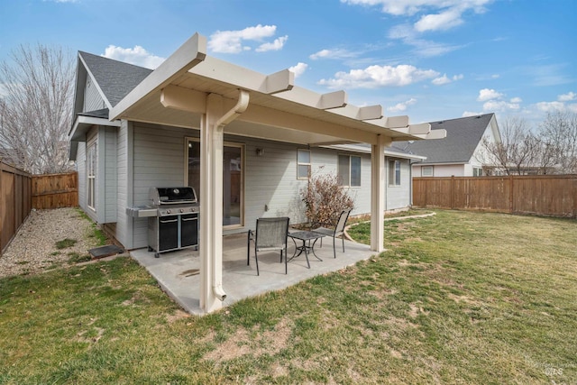 rear view of property featuring a patio, a lawn, and a fenced backyard