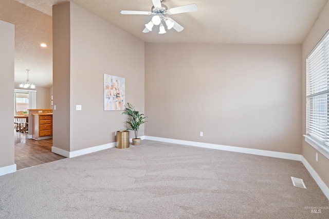 carpeted empty room featuring lofted ceiling, baseboards, and visible vents