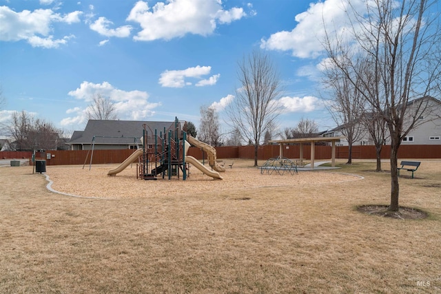 community play area with a lawn and fence