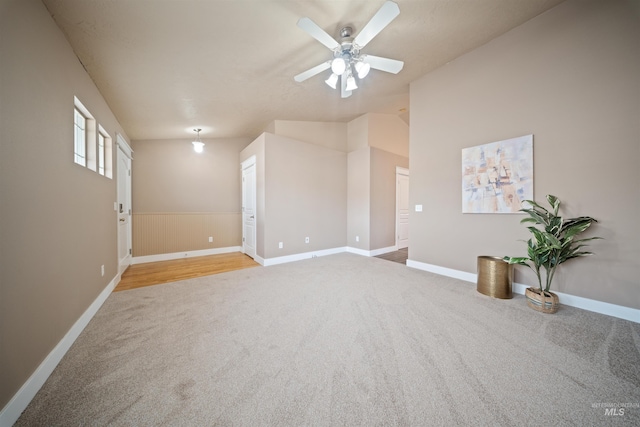 unfurnished room featuring ceiling fan, carpet floors, lofted ceiling, and baseboards