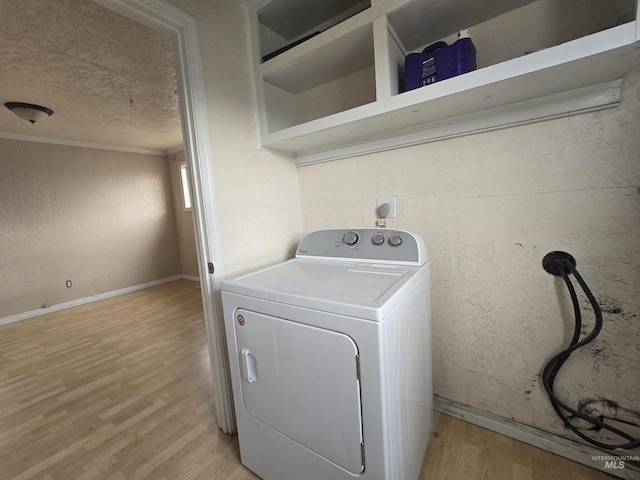 laundry area featuring light wood-style floors, laundry area, washer / clothes dryer, and a textured ceiling