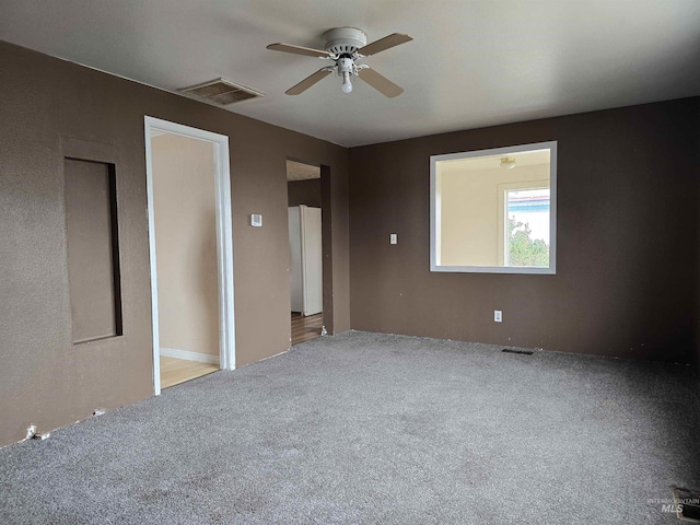 unfurnished bedroom featuring ceiling fan, carpet, and visible vents