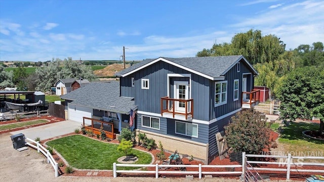 15916 Hill Top Cir, Wilder, ID 83676 - view of front facade with board and batten siding, roof with shingles, concrete driveway, an attached garage, and a balcony