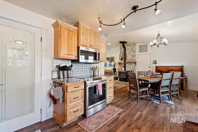 15916 Hill Top Cir, Wilder, ID 83676 - kitchen featuring appliances with stainless steel finishes, light brown cabinetry, a wood stove, dark wood-style floors, and lofted ceiling