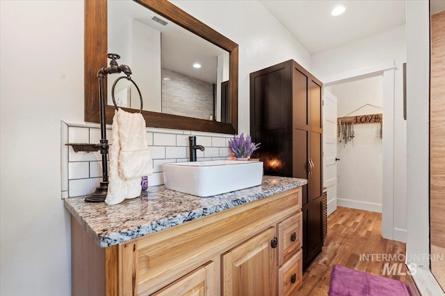 15916 Hill Top Cir, Wilder, ID 83676 - bathroom with backsplash, wood finished floors, vanity, and recessed lighting