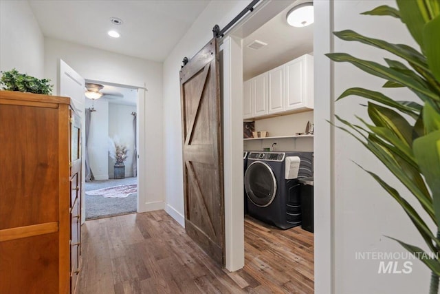 15916 Hill Top Cir, Wilder, ID 83676 - laundry area featuring a barn door, washing machine and dryer, wood finished floors, and recessed lighting