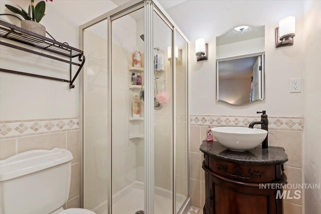 15916 Hill Top Cir, Wilder, ID 83676 - bathroom featuring tile walls, vanity, a stall shower, and wainscoting
