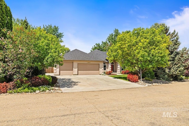 obstructed view of property featuring an attached garage, driveway, and stucco siding