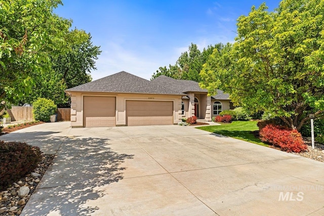 ranch-style house with an attached garage, driveway, stucco siding, and roof with shingles