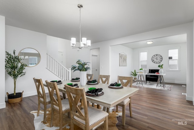 dining area featuring dark wood-type flooring and a chandelier