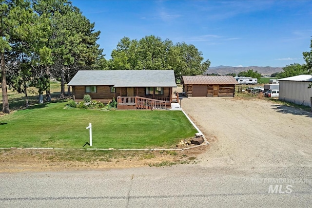 2974 Ua Ave, Emmett, ID 83617 - log-style house featuring a porch, a front lawn, a mountain view, an outbuilding, and log exterior