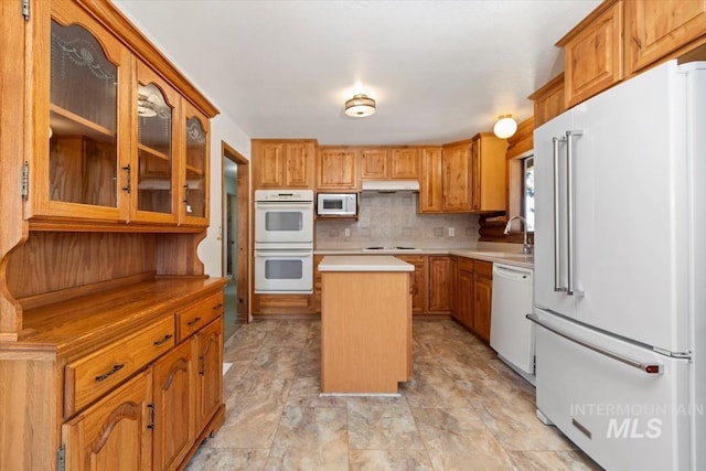 2974 Ua Ave, Emmett, ID 83617 - kitchen featuring white appliances, a center island, light countertops, glass insert cabinets, and brown cabinetry