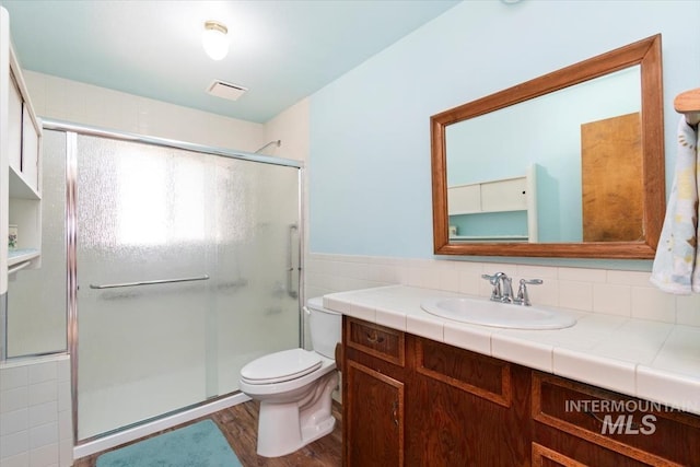 2974 Ua Ave, Emmett, ID 83617 - full bath featuring vanity, a stall shower, tile walls, wood finished floors, and wainscoting