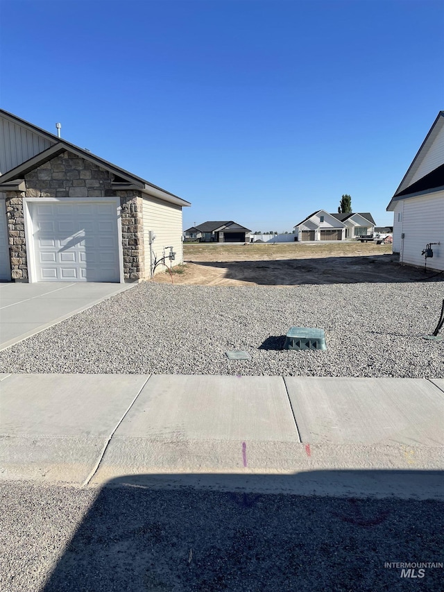 view of yard with a garage and driveway