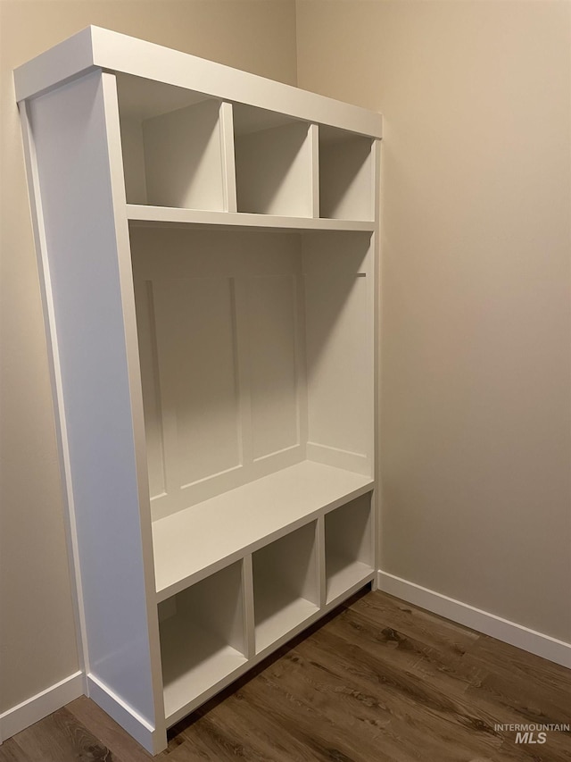 mudroom featuring dark wood-style flooring and baseboards