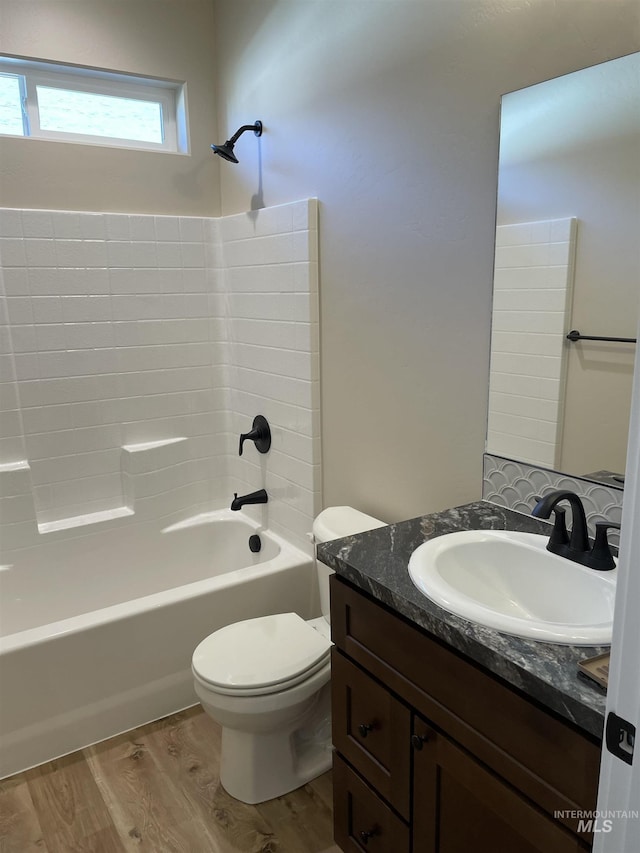 full bath featuring shower / tub combination, vanity, toilet, and wood finished floors