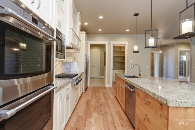 kitchen featuring a sink, light wood-type flooring, white cabinets, appliances with stainless steel finishes, and recessed lighting