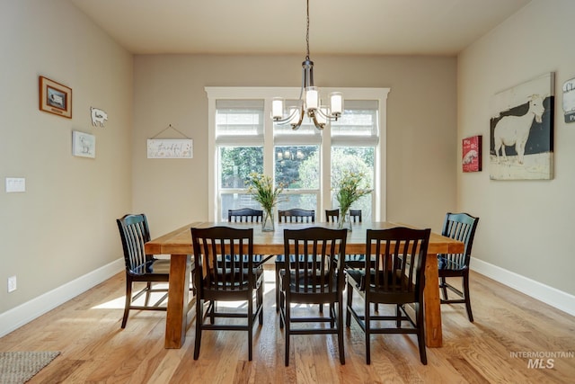 dining room with an inviting chandelier, light wood-style floors, and baseboards