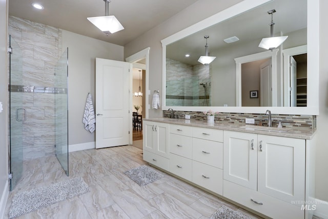 bathroom featuring marble finish floor, a sink, and a stall shower
