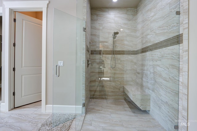 bathroom featuring a shower stall and marble finish floor