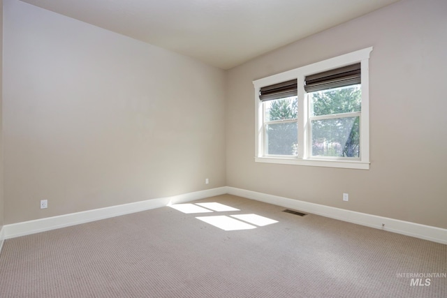 carpeted spare room with baseboards