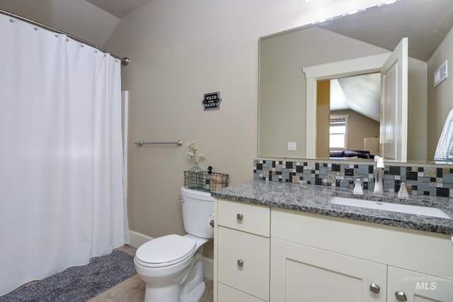 bathroom with lofted ceiling, tile patterned floors, toilet, vanity, and tasteful backsplash