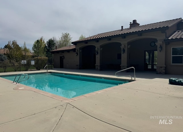 community pool featuring a patio area and fence