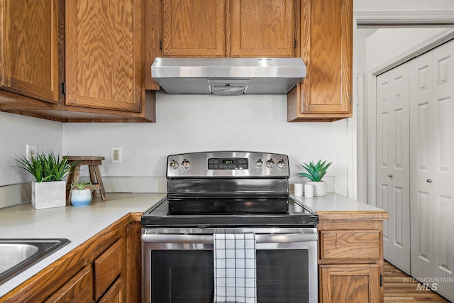 81 N Mirage St, Nampa, ID 83651 - kitchen featuring under cabinet range hood, electric stove, light countertops, and brown cabinets