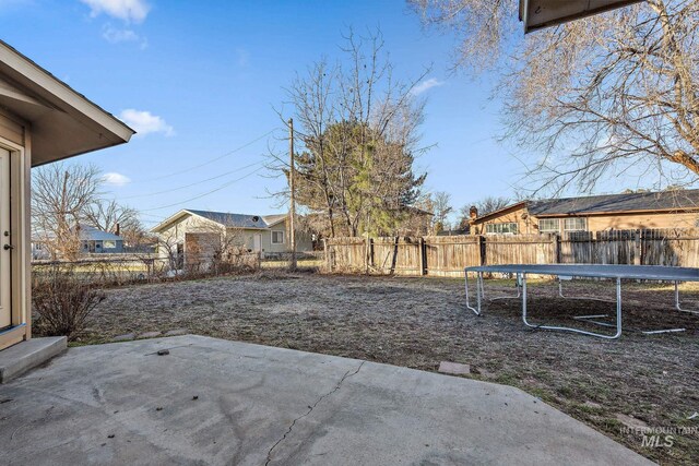 81 N Mirage St, Nampa, ID 83651 - view of yard featuring a patio area, a fenced backyard, and a trampoline