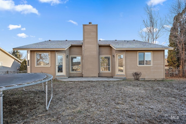 81 N Mirage St, Nampa, ID 83651 - rear view of property with a chimney, a patio, roof with shingles, fence, and a trampoline