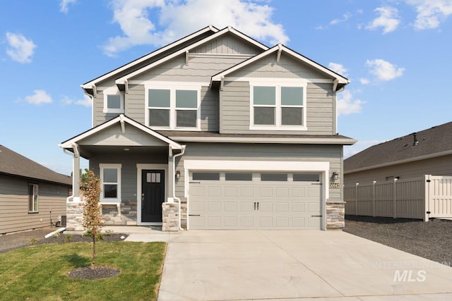 craftsman inspired home with driveway, stone siding, an attached garage, fence, and board and batten siding