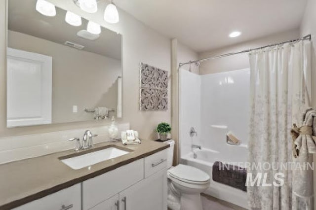 bathroom featuring vanity, shower / bath combination with curtain, and toilet